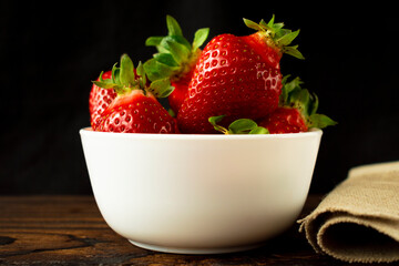 Large whole homemade strawberries in a white bowl