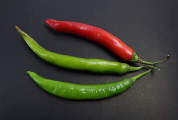 Red and green chillies on a black background