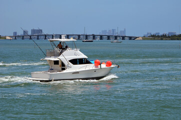 Fototapeta premium White sport fishing boat with sedan bridge on the Florida Intra-Coastal Waterway off of Miami Beach.