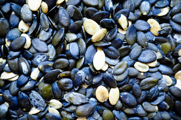Peeled oval dark pumpkin seeds macro top view . Cooking . background of pumpkin seeds