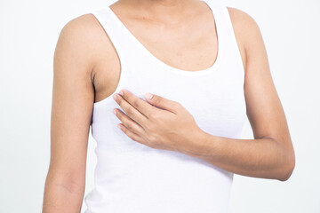 Woman hand checking lumps on her breast for signs of breast cancer on gray background. Healthcare concept.