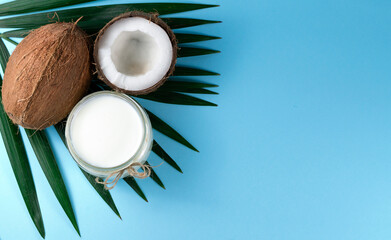 Fototapeta na wymiar coconut oil and coconut on a blue background