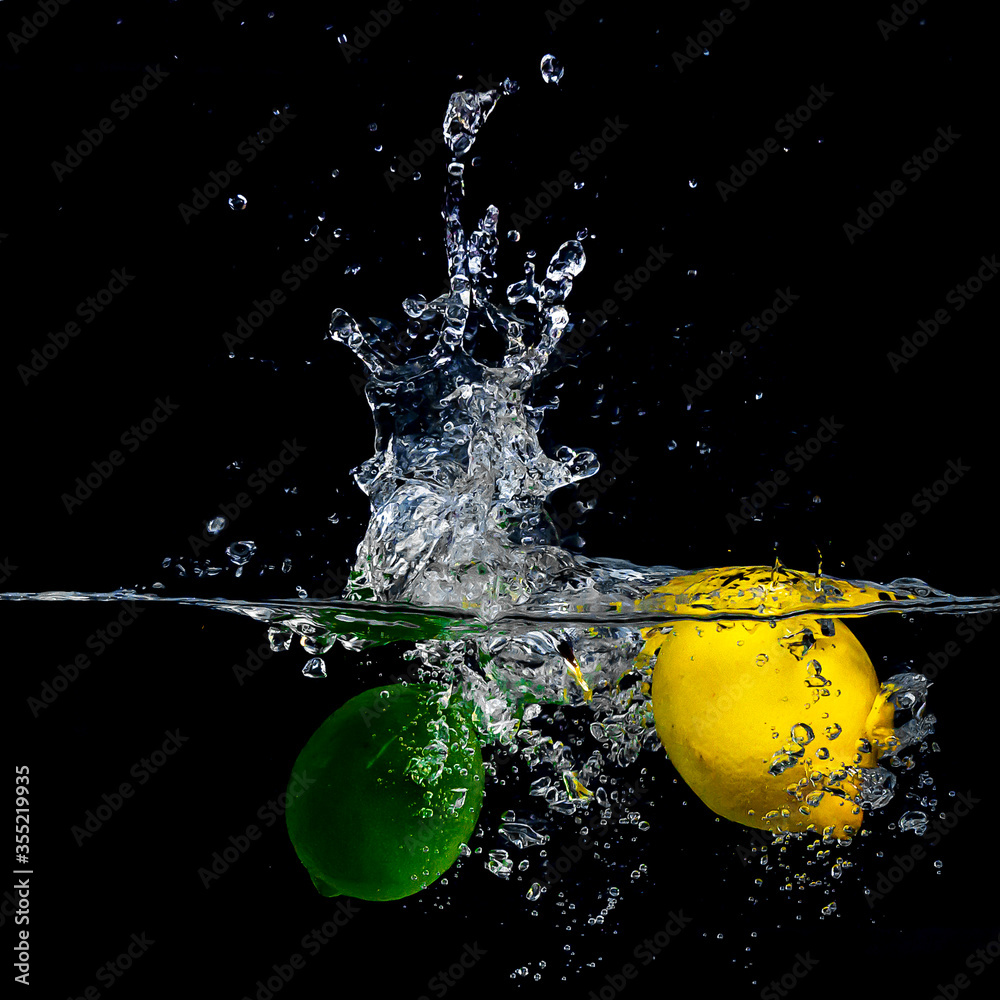 Wall mural fruit splash in water with black background