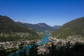 Obraz premium View of a mountain valley with a river below and houses. Norway. Otta
