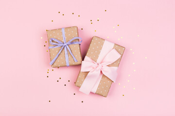 Gift or gift box and stars confetti on a pink table from above. Flat composition for birthday