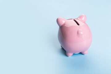pink piggy bank on blue background.  The concept of saving money or savings, investment