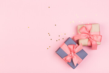 Gift or gift box and stars confetti on a pink table from above. Flat composition for birthday