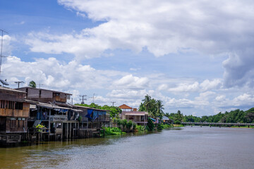 Obraz premium A house by the river near the mountains and blue sky
