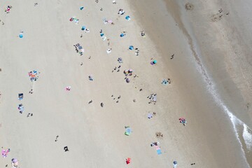 aerial view of people sunbathing on a beautiful sandy beach - taken at camber sands, east Sussex, UK  