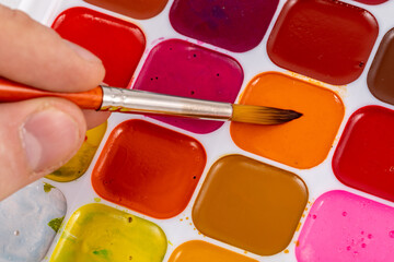 Set of watercolor paints and synthetic brushes for painting. Drawing process.