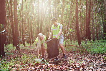 Fototapeta premium Two volunteers do CSR garbage collection at public forest, Social Responsibility and waste activity on Wold Environment day