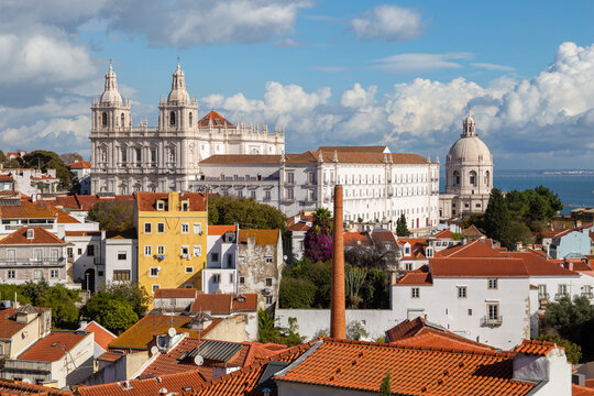 Lisbon, Portugal: Alfama district under cloudy sky on a sunny day featuring Church - Monastery of Sao Vicente de Fora and Santa Engracia (National Pantheon) as famous landmarks and attractions.