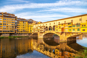 Obraz premium Florence Italy: Old Bridge (Ponte Vecchio) and its reflection in Arno river on a sunny morning. Famous landmark and major tourist attraction in Firenze Italia Europe.