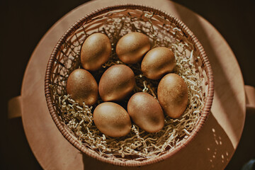 Golden painted eggs in a basket. Easter decor