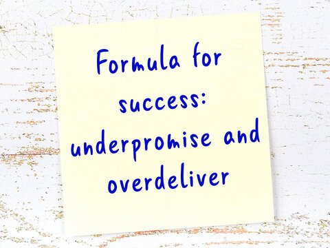 Yellow sticky note on wooden wall with wise quote
