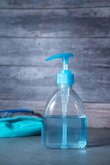 face mask, sanitizer on wooden table with copy space 