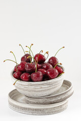 red berry cherry  in ceramic bowl on white background, copy space