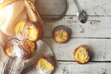 Fresh cheesecakes in a basket on a wooden table in the sun. Homemade cake. Confectionery.