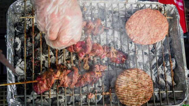 Cinemagraph of smoke emitted from cooking different types of meat on a hot BBQ grill. Close up top view, loop with selective focus.