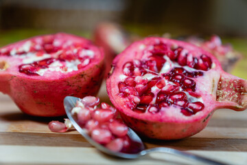 pomegranate fruit sliced on a wooden cutting board. Ripe pomegranate closeup with selective focus