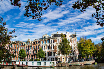 Fototapeta premium View of Amsterdam with Canal and Clouds