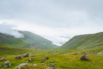 Fototapeta na wymiar Kazbegi, Georgia - Mountain landscape of Mount Kazbegi landscape with dramatic clouds up in the trekking and hiking route.
