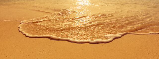 surf of soft waves on tropical golden sand beach at dusk