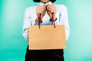 People life style: Woman hold brown shopping paper bag by using both hands with copy space of the bag