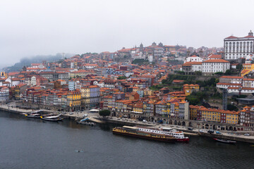 Fototapeta na wymiar Colorful houses of Porto Ribeira, traditional facades, old multi-colored houses with red roof tiles on the embankment in the city of Porto. Unesco World Heritage site, Portugal.