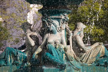 Sitting half-naked female statues in the center of the fountain at Rossio (King Pedro IV) square in Lisbon Portugal.