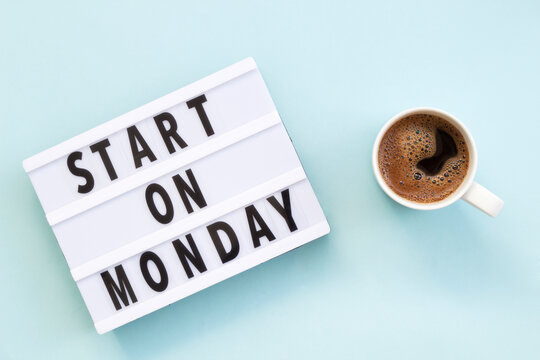 Text "start on monday" on lightbox and cup of coffee. Ð¡oncept of new beginnings. Start of working week. Top view on blue background.