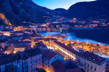 Kotor Montenegro at night. City lights of medieval town by the famous bay.  Tourist destination and UNESCO world heritage site at dusk. Aerial view.