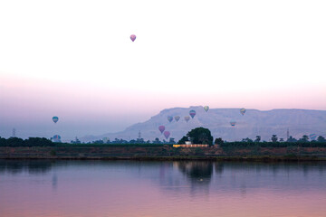 Nile river at sunrise with hot air balloons in Luxor, Egypt.
