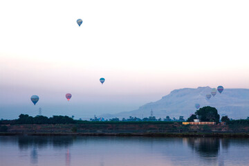 Nile river at sunrise with hot air balloons in Luxor, Egypt.
