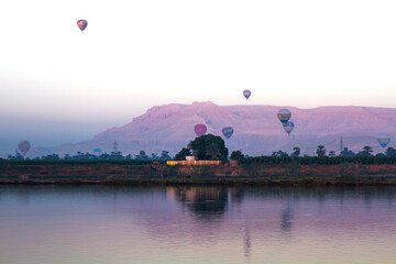 Nile river at sunrise with hot air balloons in Luxor, Egypt.
