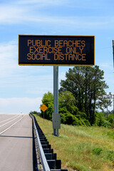 Digital Street Sign PUBLIC BEACHES EXERCISE ONLY SOCIAL DISTANCE at the beach because of he Coronavirus 