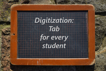 Alter Schultafel mit der englischen Aufschrift: Digitalisierung: Tablet für jeden Schüler