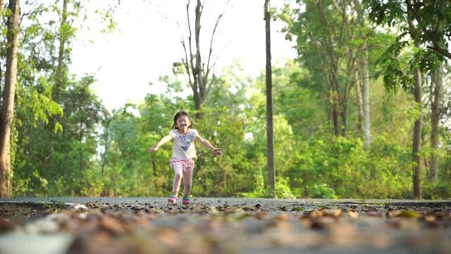 The Cute kids runing together in the forest and looking at the camera cute kids playing in the forest. Children play fun outdoor park concept. cheerful smiling little boy with big backpack jumping 