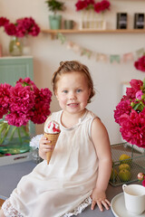 Girl with peonies bouquet and with ice cream. Bouquet of peonies. Child girl with flowers. Children Protection Day. Emotions of happiness and joy. Mothers day. Happy childhood