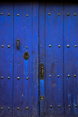 Fototapeta premium Old rustic wooden door with different layers of blue paint
