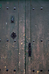 Old rustic wooden door with different layers of cracked paint