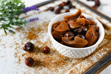 Sweet and soft dried Apple and rose hips prepared for dessert, decorated with a sprig of lavender and dry fruits on an unusual white and rusty metal background
