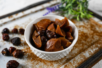 Sweet and soft dried Apple and rose hips prepared for dessert, decorated with a sprig of lavender and dry fruits on an unusual white and rusty metal background