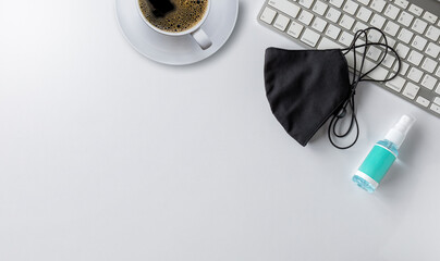 new normal concept. flat lay, top view office table desk.hot coffee cup, face mask, alcohol spray,...