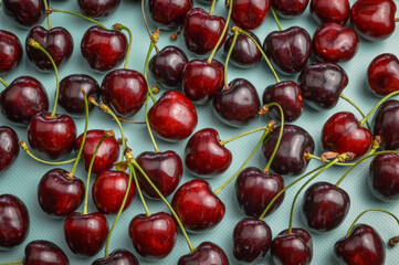 Red organic ripe cherries on a light blue background