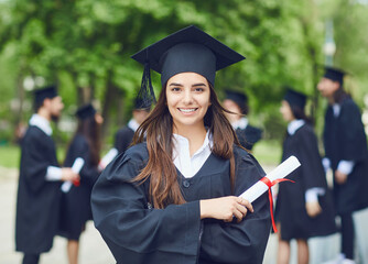 A young female graduate against the background of university graduates.