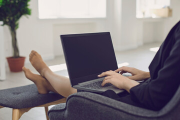 Crop businesswoman working online using laptop at home.