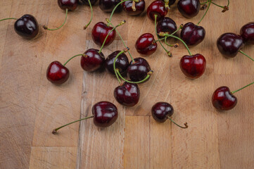 Naklejka na ściany i meble Red organic ripe cherries on a wooden background close up
