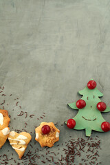 christmas cookies, christmas tree and red cherries on background