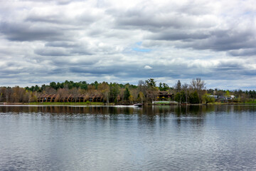 Fototapeta premium beautiful landscape of waterfront townhouses and yacht on a lake in Canada, Quebec in summer